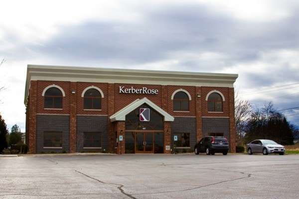 A brick building with cars parked in front of it, offering career opportunities for those looking to grow professionally in the field of kerberose.